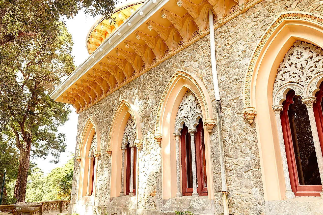 Carved Moorish-style windows and a scalloped cornice on the sunlit walls of Monserrate Palace
