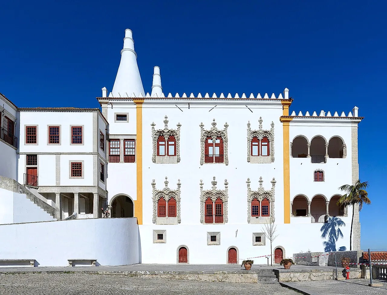 The white façade of the National Palace of Sintra with its two conical kitchen chimneys and Manueline windows