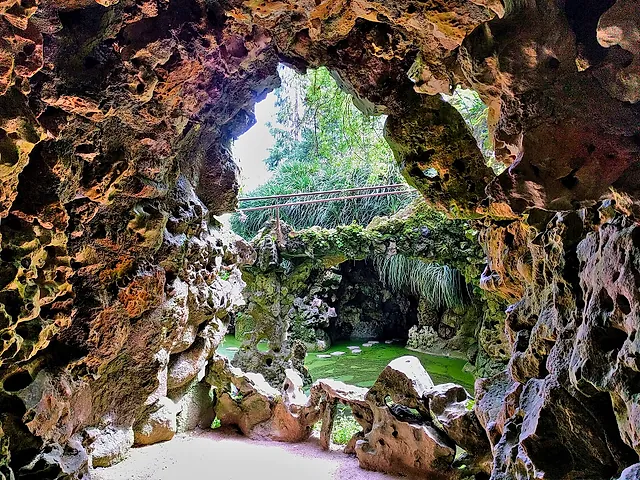 Looking out from a rocky grotto over the Waterfall Lake at Quinta da Regaleira