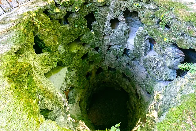 Looking down into the Initiation Well at Quinta da Regaleira, with its mossy spiral walls