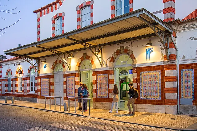 The red-and-white tiled façade of Sintra railway station with travellers outside
